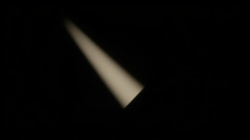 A single edge of light on an object in deep black shadow, abstract concept